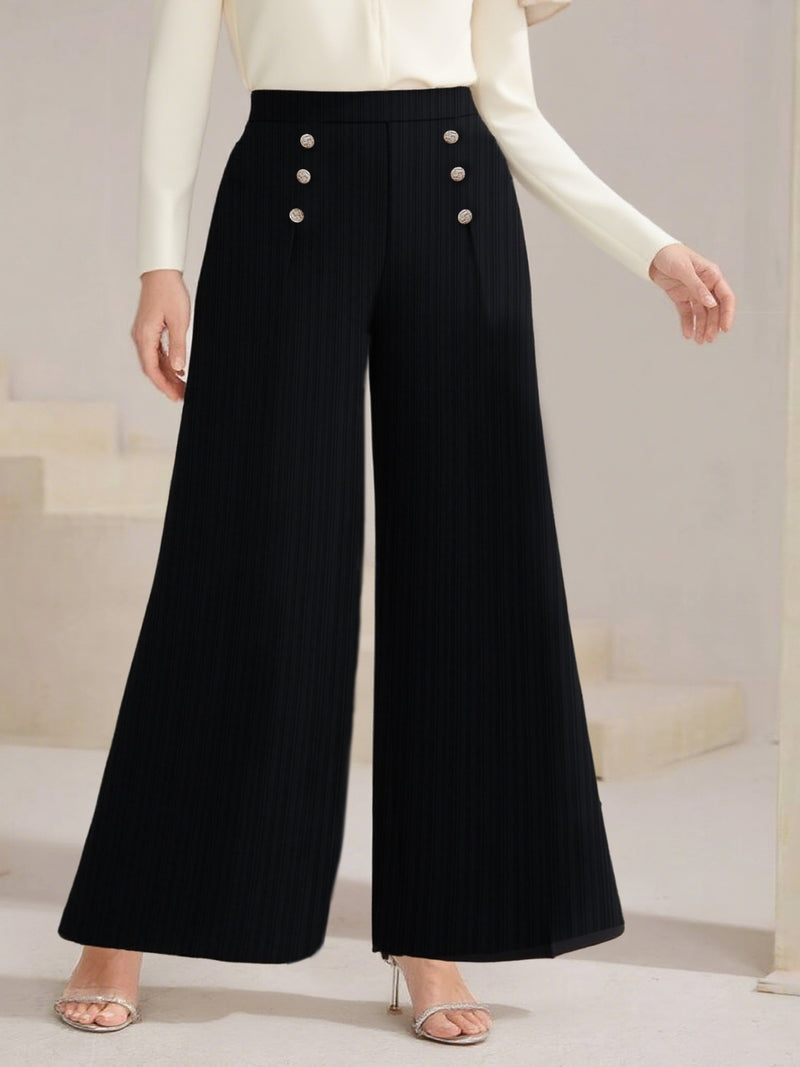 Black wide-leg pants with button details worn by a person on a neutral background