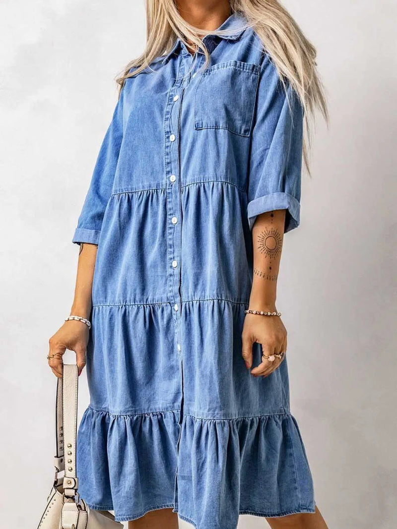 Woman wearing a blue denim dress against a plain background