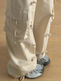 Beige pants with drawstrings worn by a person on a wooden floor
