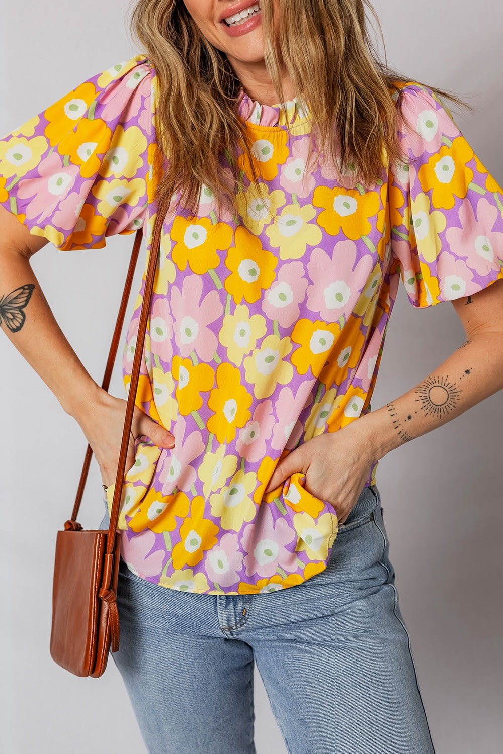 Woman wearing a colorful floral blouse with a plain background