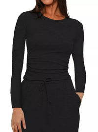 Black long-sleeve top worn by a person on a white background