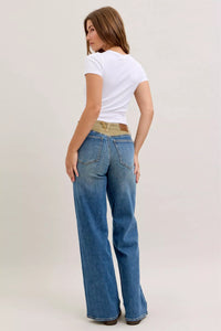Woman wearing blue jeans and a white t-shirt on a plain background