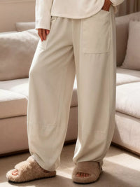 Person wearing beige pants and slippers in a living room setting