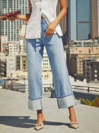 Person wearing light blue jeans with a cityscape background