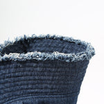 Close-up of a denim bucket hat with frayed edge on a white background