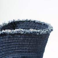 Close-up of a denim bucket hat with frayed edge on a white background