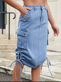 Blue denim skirt with drawstring details worn by a person.