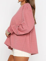 Person wearing a pink and white striped shirt with a plain background