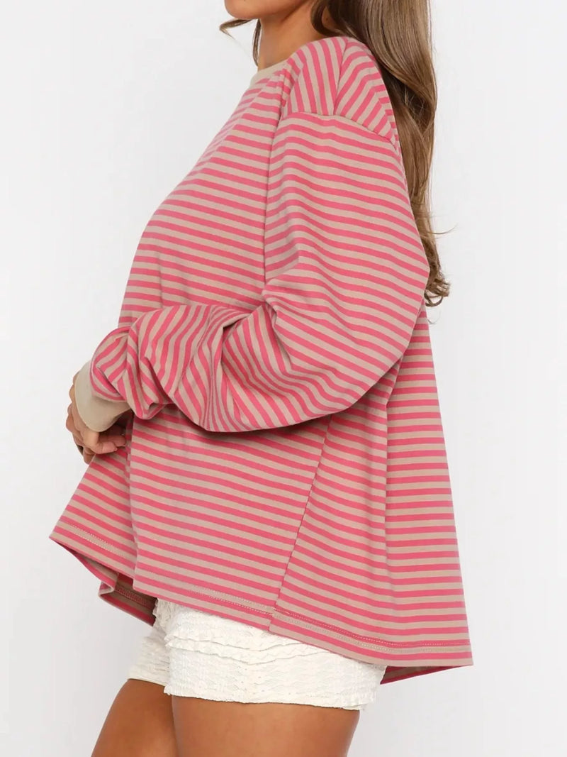 Person wearing a pink and white striped shirt with a plain background