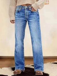 Person wearing blue jeans with a neutral background