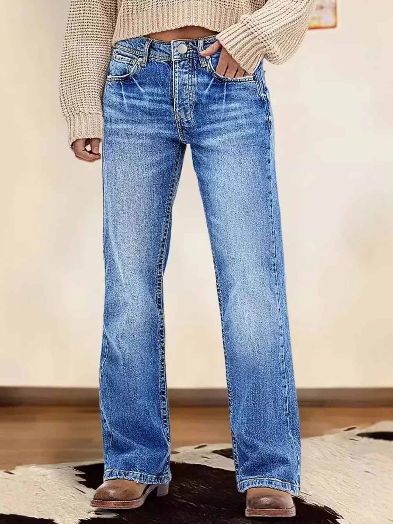Person wearing blue jeans with a neutral background
