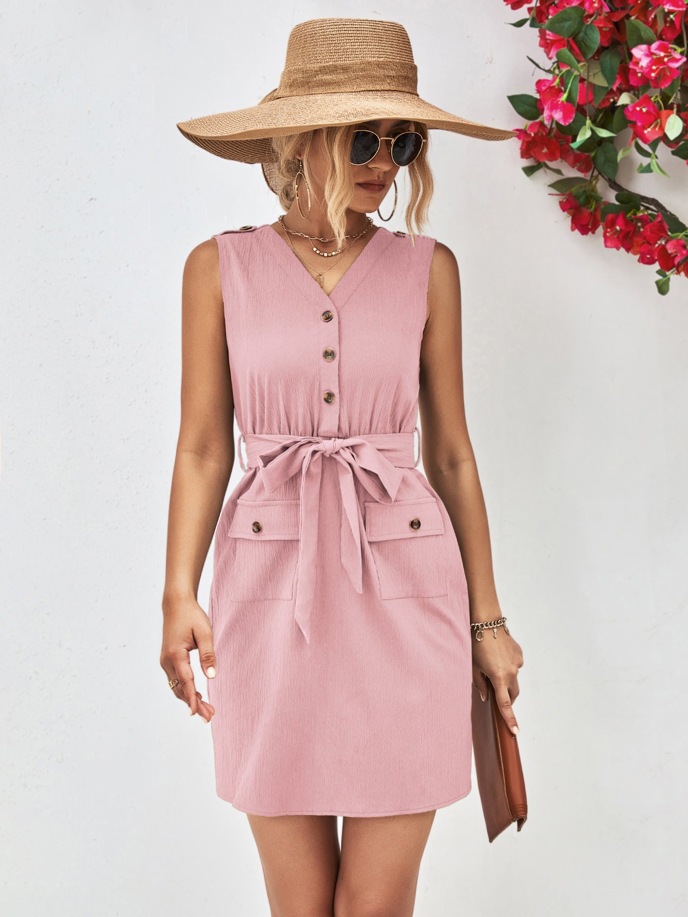 Woman wearing a pink dress with a straw hat against a white background