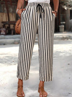 Person wearing black and white striped pants with a blurred background