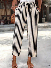Person wearing black and white striped pants with a blurred background