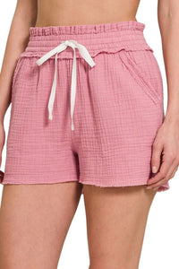 Pink shorts with a drawstring on a white background