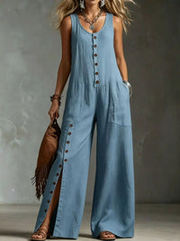 Woman wearing a blue denim jumpsuit with a plain background