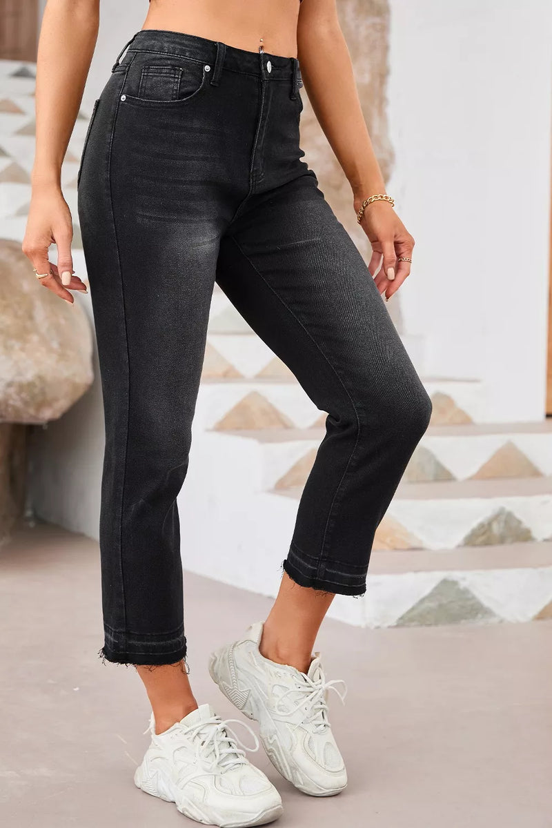 Person wearing black jeans and white sneakers in a casual setting