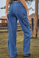 Person wearing blue cargo pants standing outdoors with a blurred background