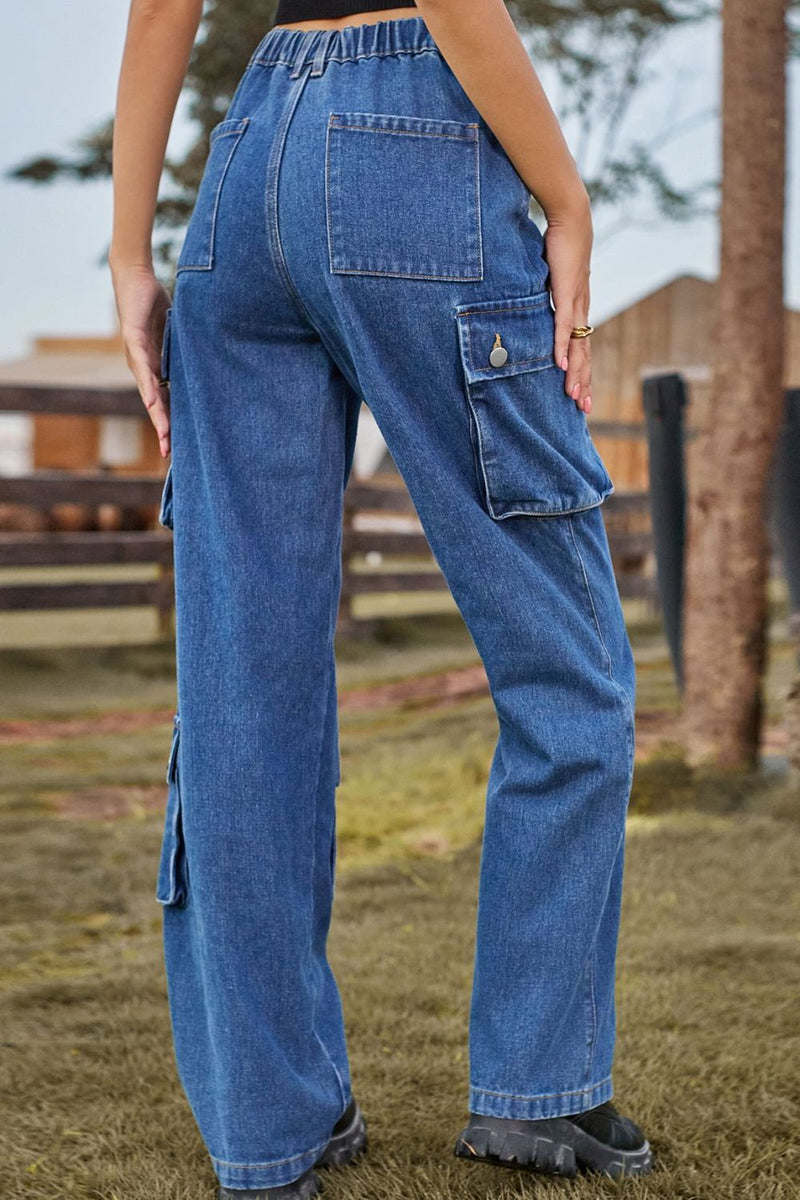 Person wearing blue cargo pants standing outdoors with a blurred background