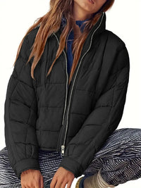 Person wearing a black puffer jacket on a white background