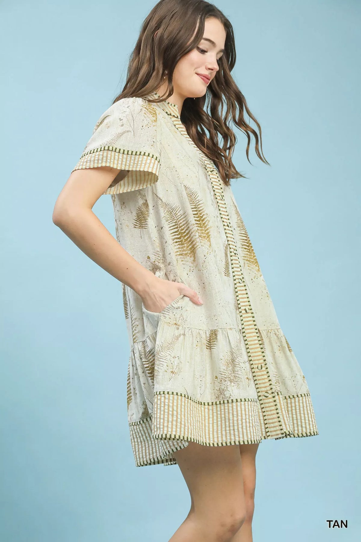 Woman wearing a patterned dress against a light blue background