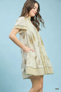 Woman wearing a patterned dress against a light blue background