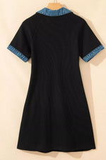 Black dress with blue trim on a beige background