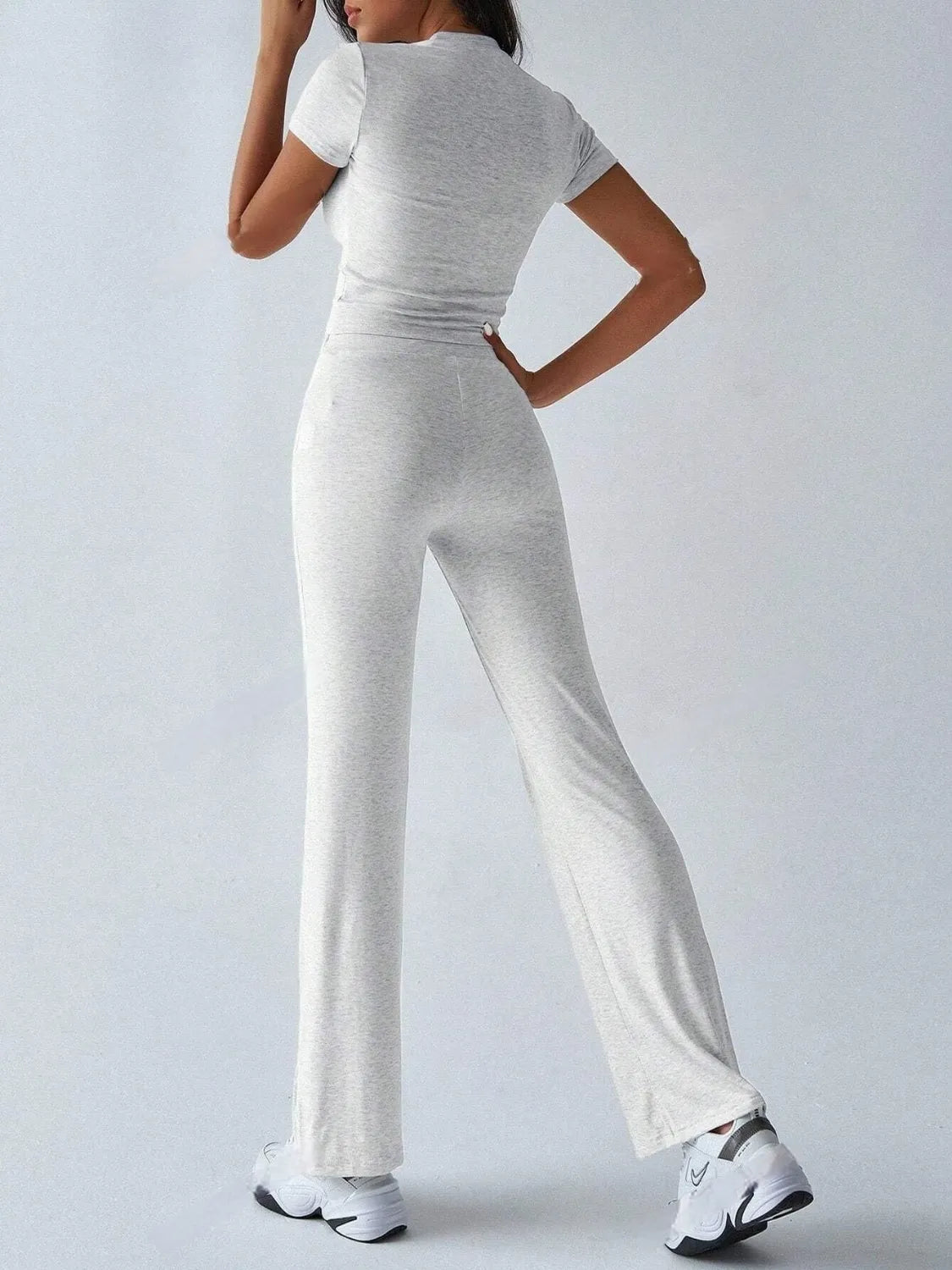 Person wearing a gray jumpsuit on a white background