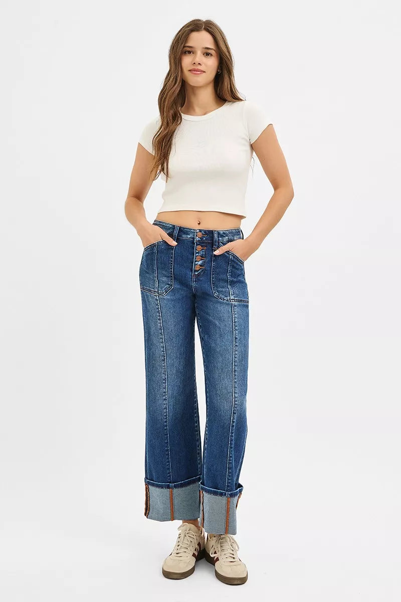 Woman wearing a white crop top and blue jeans on a white background