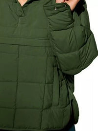 Green puffer jacket worn by a person on a white background