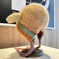 Knitted hat with colorful band on a mannequin head against a blurred indoor background