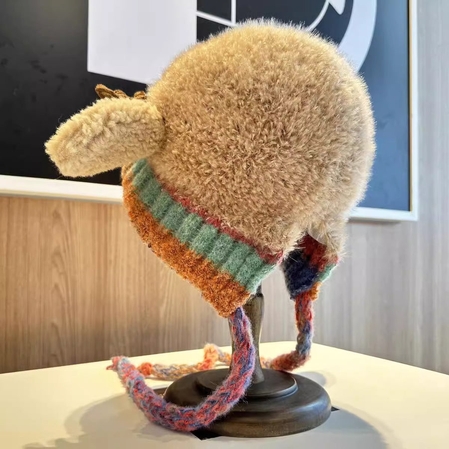 Knitted hat with colorful band on a mannequin head against a blurred indoor background