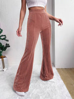 Person wearing brown corduroy pants and a white top indoors.