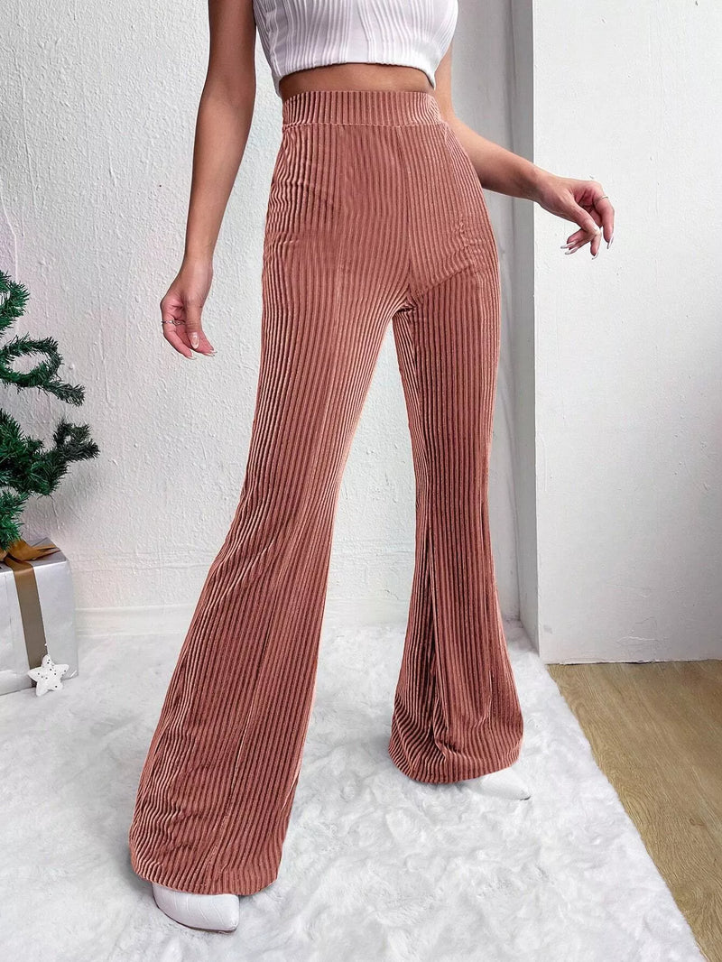 Person wearing brown corduroy pants and a white top indoors.
