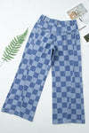 Blue checkered pants on a white background with a leaf and magazine.