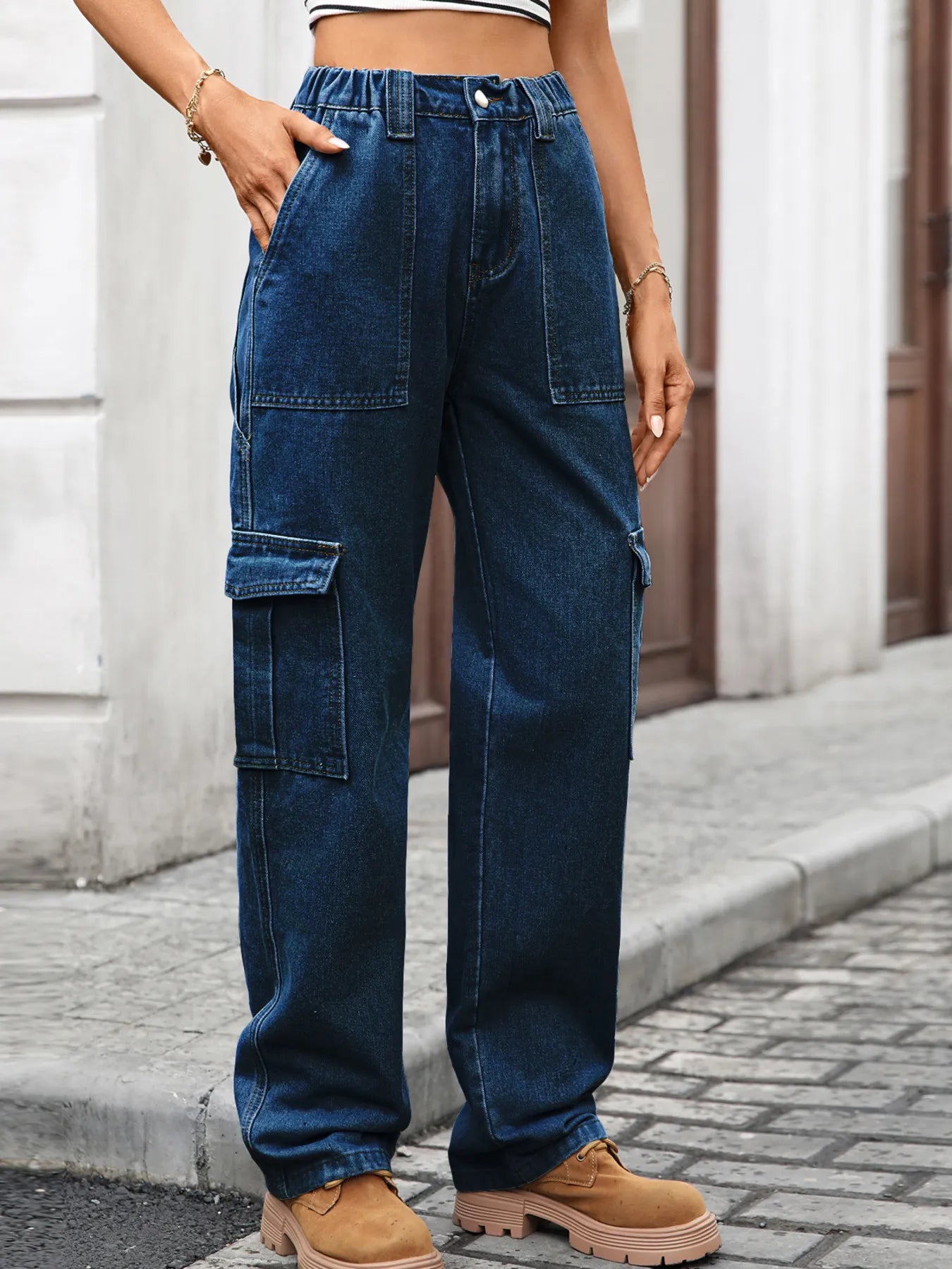 Person wearing blue cargo pants on a street.