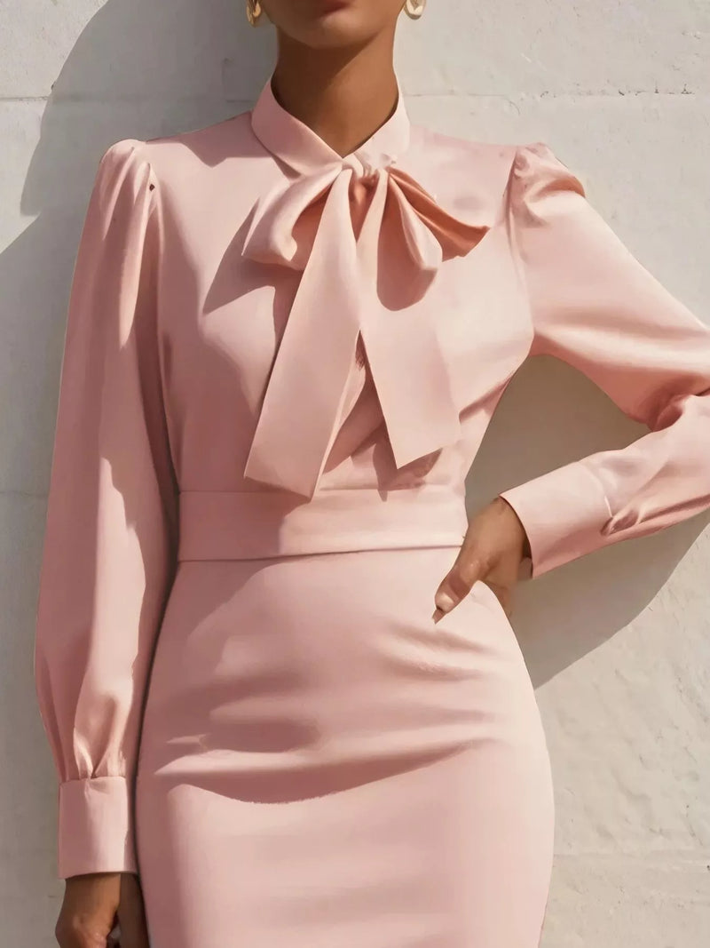 Pink dress with a large bow detail on a neutral background