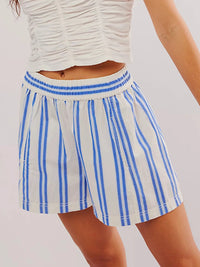 Blue and white striped shorts worn by a person on a plain background
