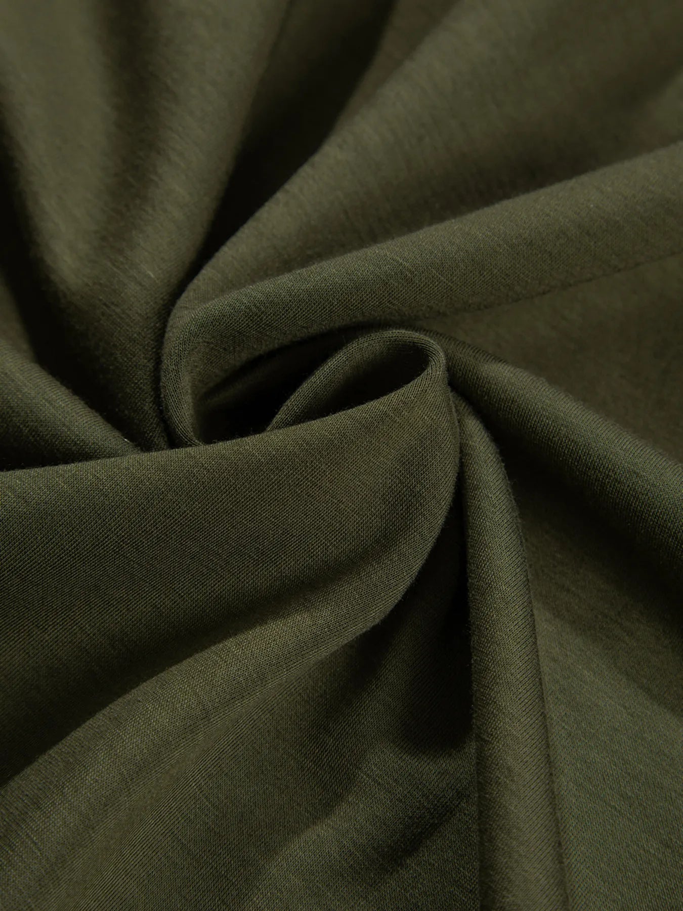 Close-up of dark green fabric with folds