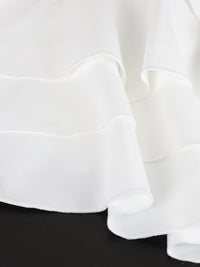 Close-up of white fabric with ruffled edges on a black background