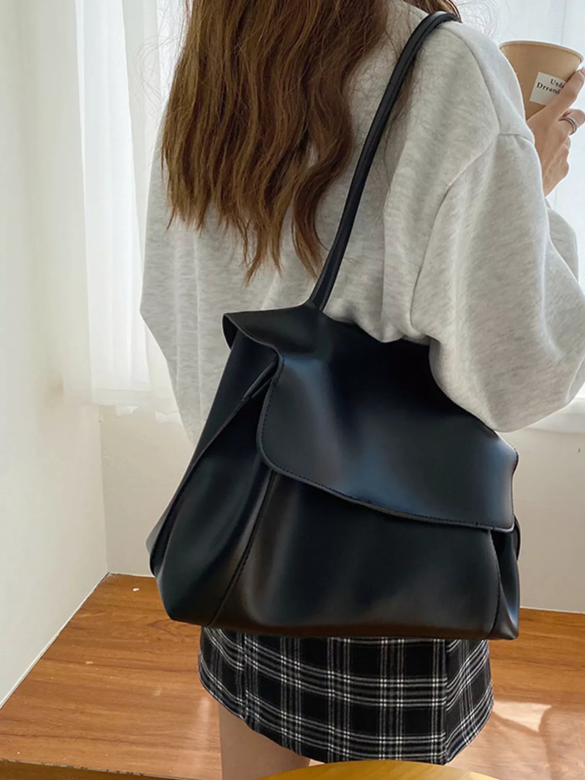 Person wearing a black backpack indoors