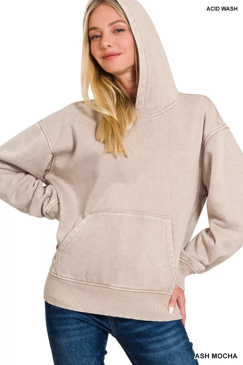 Woman wearing a beige hoodie with 'Acid Wash' text on a white background