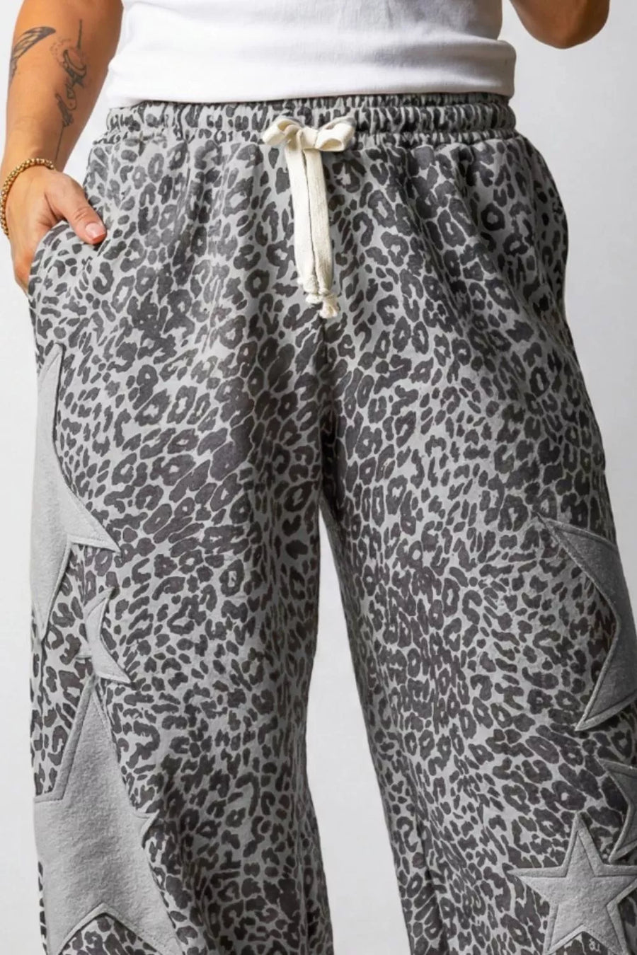 Leopard print sweatpants with a drawstring on a plain background
