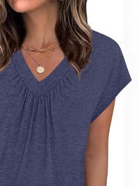 Woman wearing a blue top with a plain background