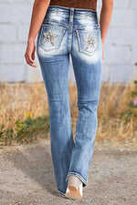 Person wearing blue jeans with star designs on a natural background