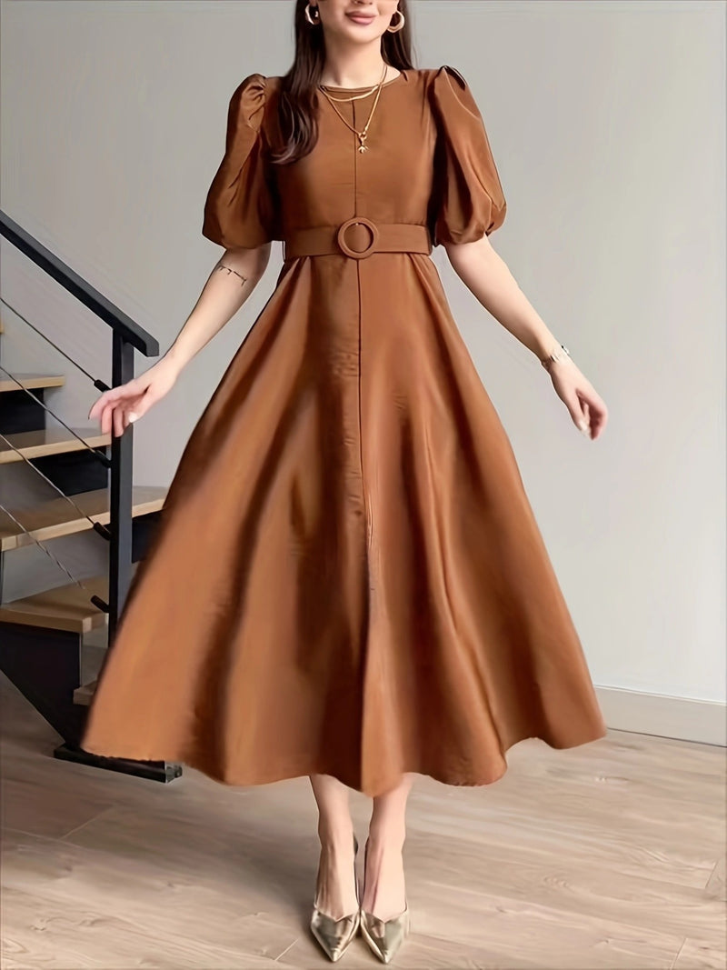 Woman wearing a brown dress with puff sleeves in an indoor setting.