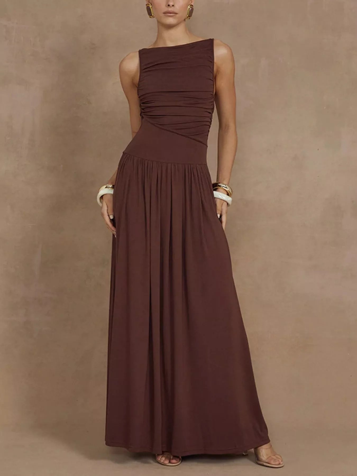 Woman wearing a brown one-shoulder dress against a beige background