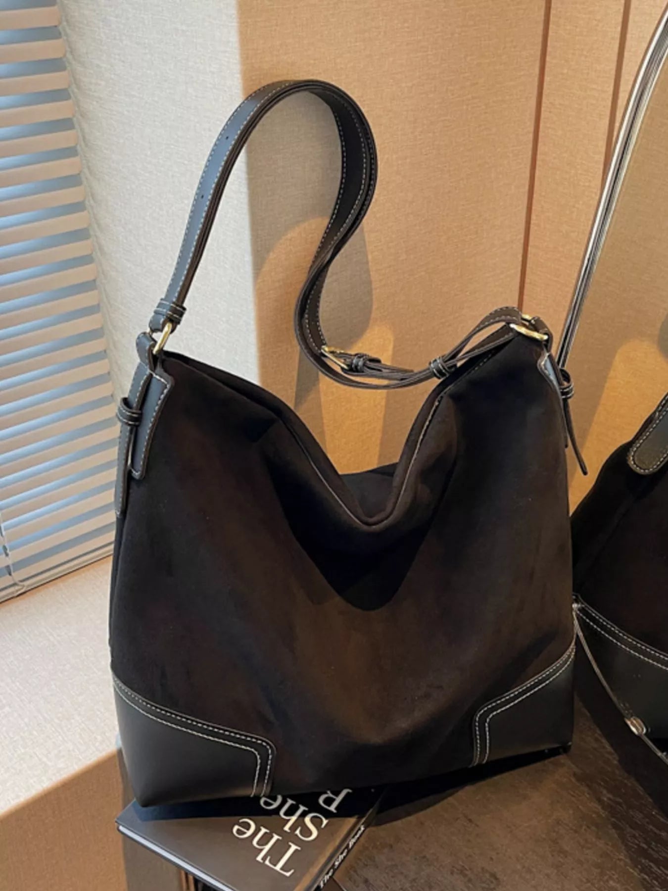 Black handbag on a surface with a blurred background