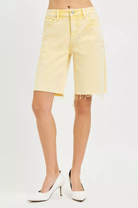 Yellow denim shorts worn by a person on a white background