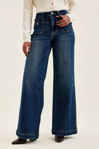 Person wearing blue wide-leg jeans on a plain background